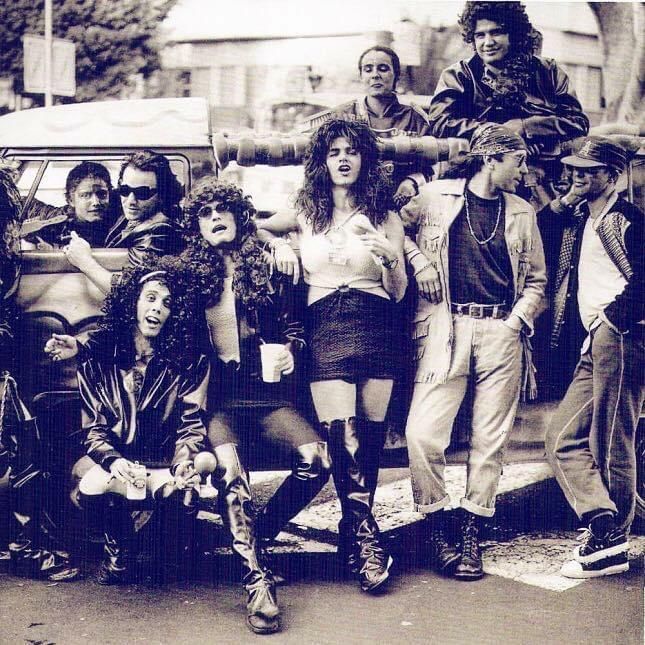 Carnavaleros posan delante de un coche engalanado conducido por Bono