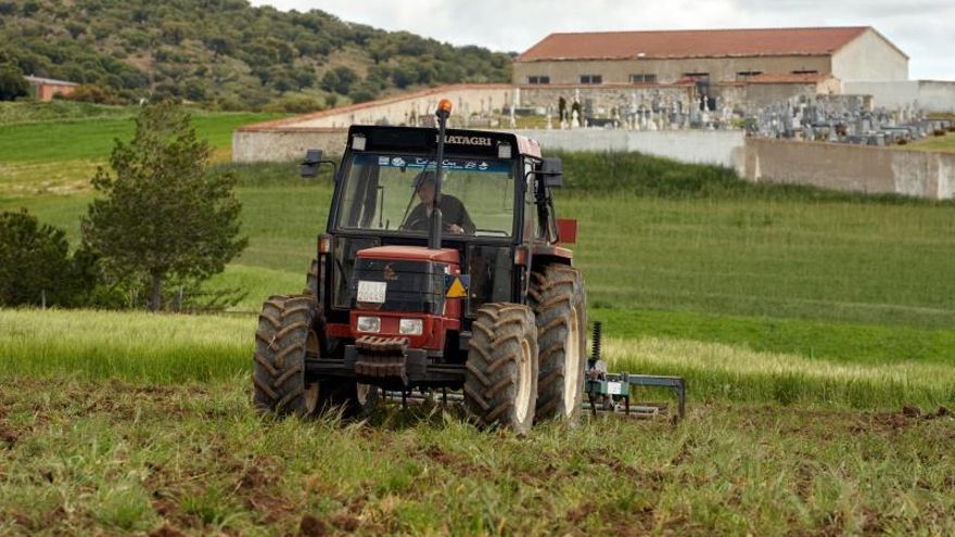 Un hombre ara la tierra con su tractor en Solana de Rioalmar, Ávila.