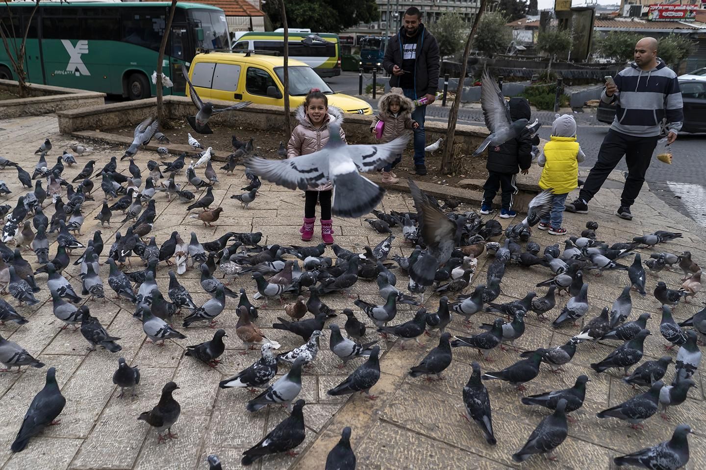 Unos niños dan de comer a las palomas en Nazaret (Israel), la ciudad más poblada del Distrito Norte. | JOAQUÍN GÓMEZ SASTRE