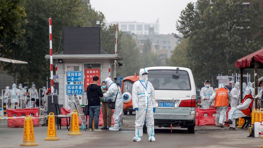 Epidemic prevention and control staff wearing protective suits stand guard at an entrance to a residential neighbourhood which is under lockdown due to new COVID-19 cases at the Hongfuyuan residential community in Changping district of Beijing, China, 25 October 2021.