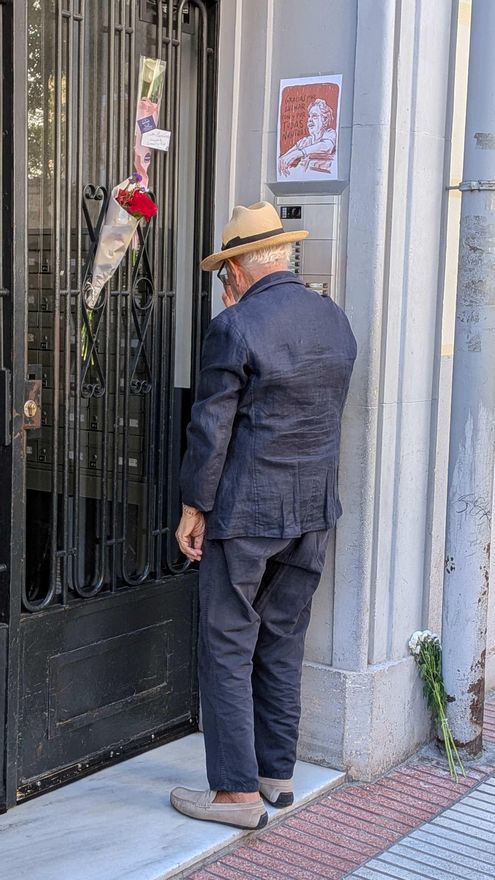 Domenico, de espaldas frente al portal de Maricarmen, después de dejarle flores