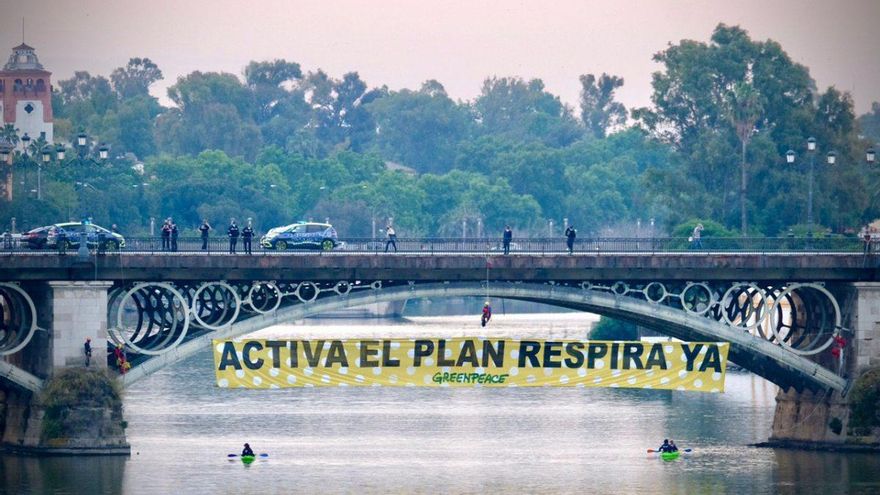 Greenpeace protesta con una pancarta de lunares en el puente de Triana para que se restrinja el tráfico en el centro de Sevilla