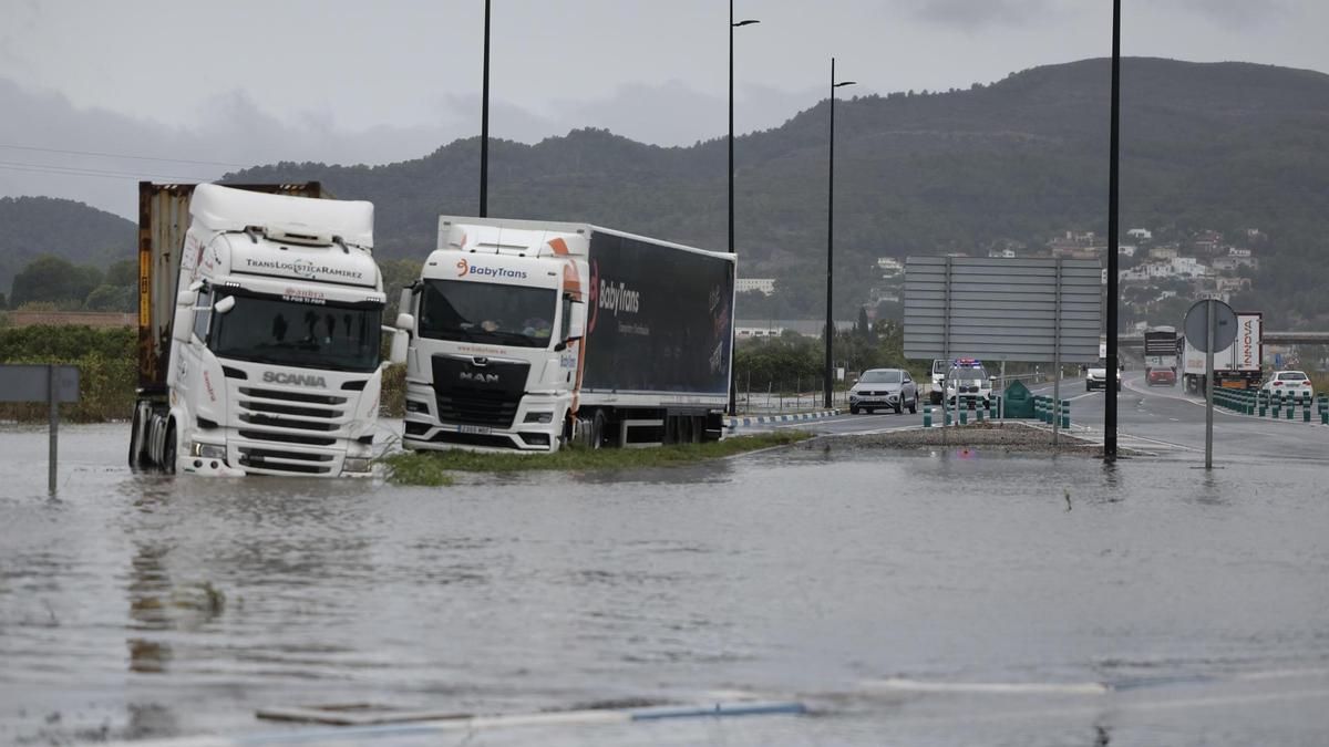 Varios camiones atrapados en una zona inundada en la N332, a las afueras de Gandía, este lunes.
