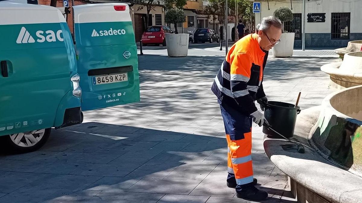 Un operario de Sadeco limpia una pintada en un banco.