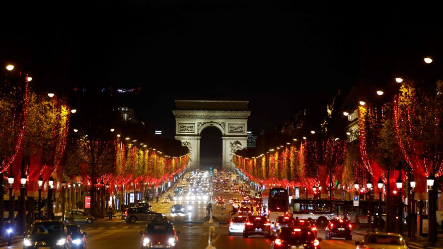 La avenida de los Campos Elíseos iluminada de rojo tras el encendido de las luces de Navidad en París.