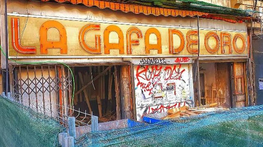 El cartel de La Gafa de Oro antes de ser retirado, cuando desmontaban la vieja óptica. // Mures