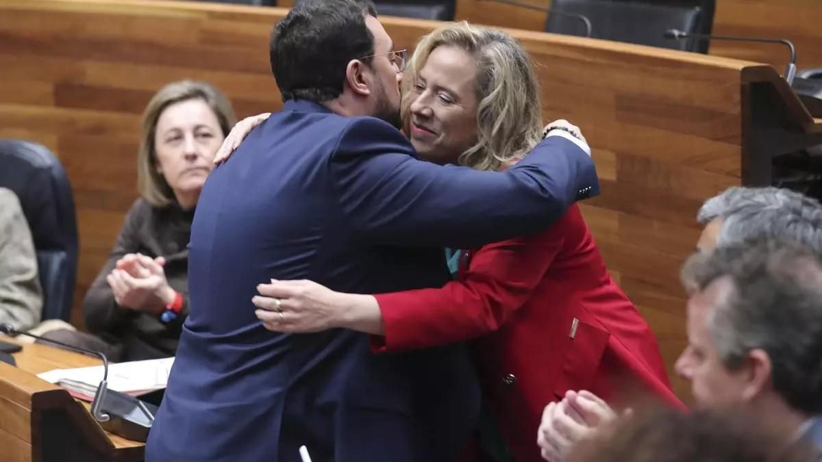Belarmina Díaz, el mismo día en que comunicó en el parlamento asturiano que dimitía de su cargo como consejera es abrazada por el presidente del Principado, Adrián Barbón.