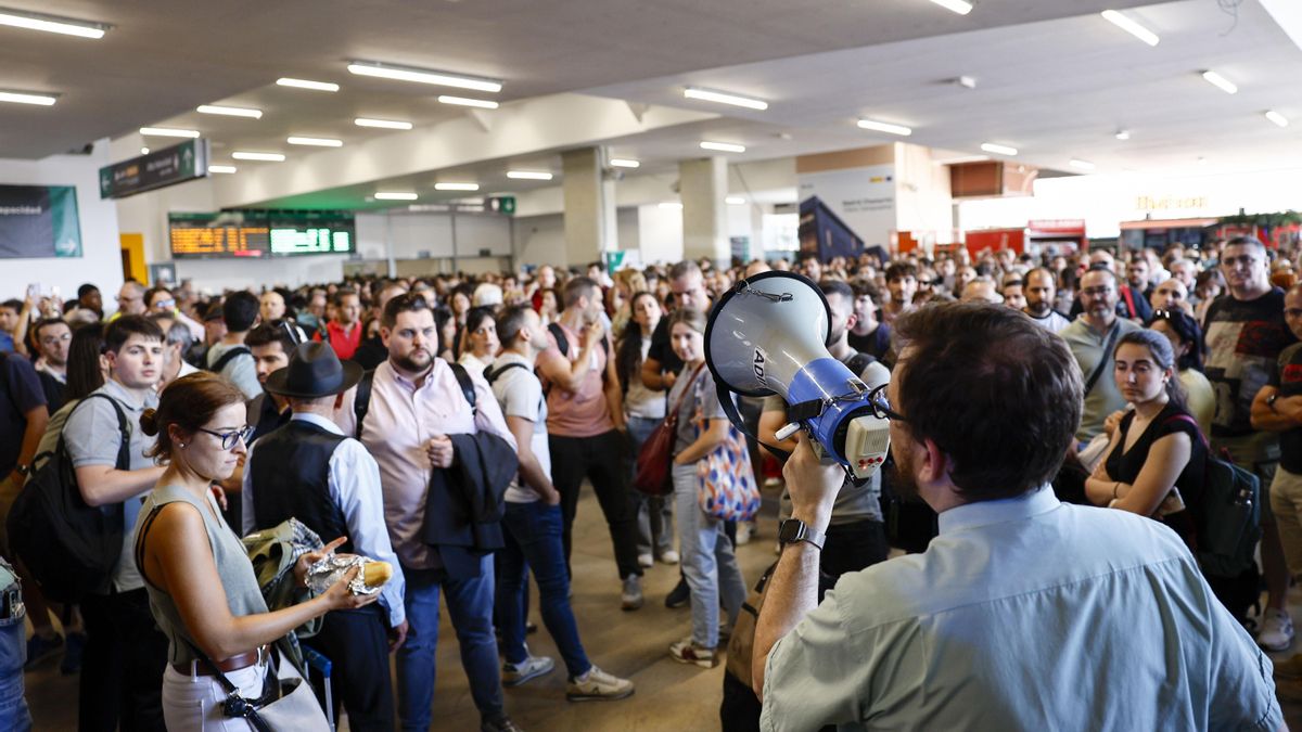 Un empleado informa a los pasajeros sobre los retrasos en la estación de Madrid-Chamartín después de que este jueves la circulación de trenes de alta velocidad se viera interrumpida por una falta de tensión eléctrica en la estación.