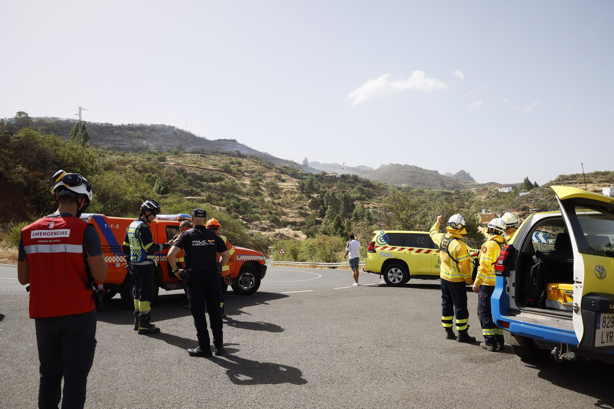 Efectivos de tierra intervienen para sofocar el incendio registrado este lunes en Cazadores, en Telde (Gran Canaria).