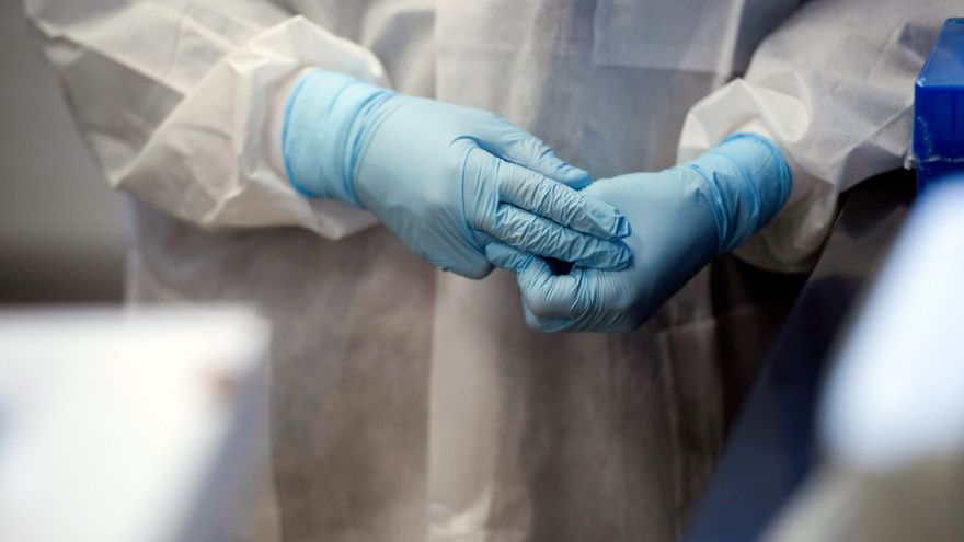Imagen de un investigador poniéndose los guantes en unas instalaciones de investigación microbiológica en la Universidad de Minnesota durante un ensayo para averiguar si la hidroxicloroquina puede prevenir o reducir la gravedad del coronavirus. Foto: Reuters.