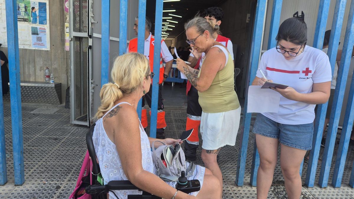 Voluntarios de Cruz Roja toman los datos de las personas desplazadas por el incendio de Los Gallardos (Almería) hasta el polideportivo Vista Alegre de Garrucha