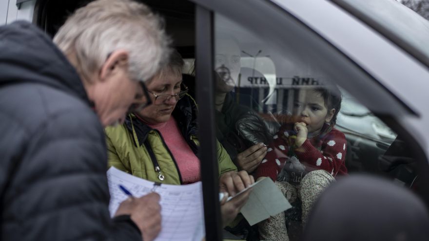 Un voluntario registra los datos de Olga a su llegada al punto de recepción de evacuados, en Zaporiyia.