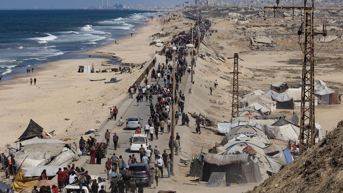 Palestinos desplazados caminan por la carretera costera de Al-Rashid, en el centro de la Franja de Gaza, el 10 de octubre de 2025.