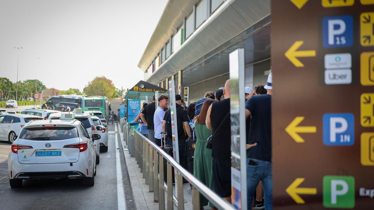 Turistes nouvinguts a Eivissa esperen, amb els seus equipatges, davant de la garita dels taxis