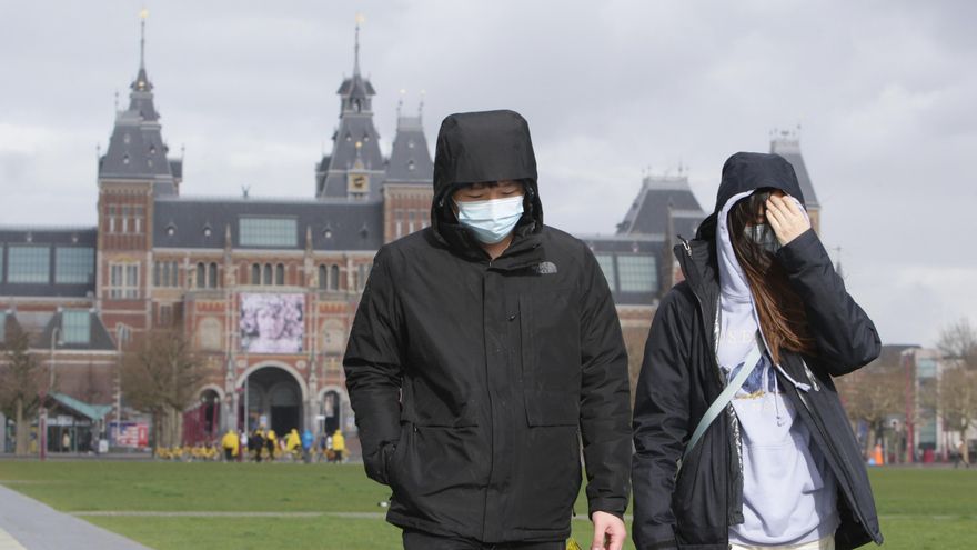Two tourists wearing surgical masks, walk near the Rijksmuseum amid the coronavirus outbreak