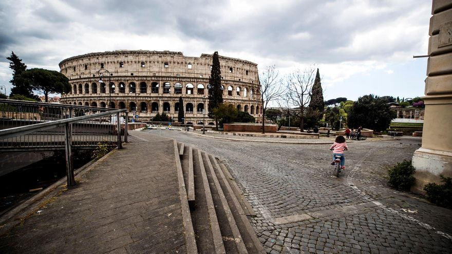 Una niña monta en bicicleta frente a la plaza desértica del Coliseo Romano, el lunes en Roma (Italia). EFE/ Angelo Carconi