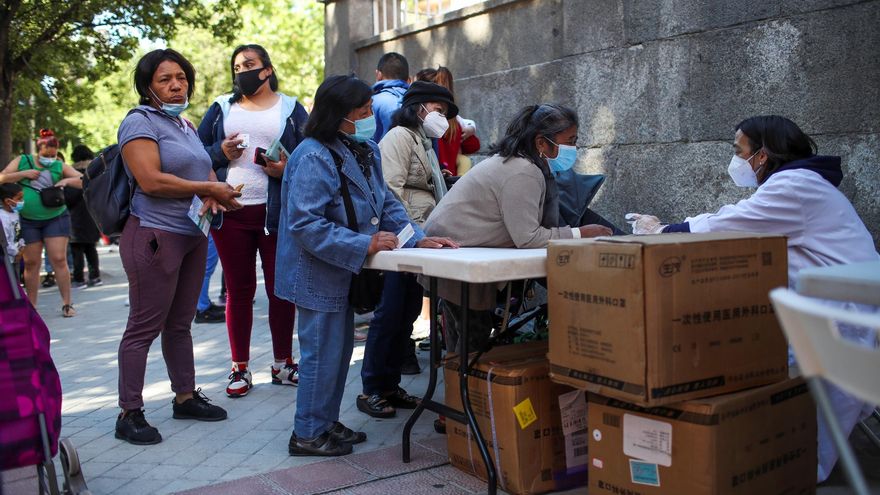 Mientras miles de madrileños preparan sus vacaciones tras un año de restricciones a causa de la pandemia, todavía perduran las colas del hambre en la capital organizadas por asociaciones vecinales, fundaciones y entidades solidarias que piden más donaciones para llenar sus despensas. En la imagen, decenas de personas acuden este sábado al reparto de alimentos que la Fundación Madrina realiza en la Plaza San Amaro en Madrid. EFE/David Fernández