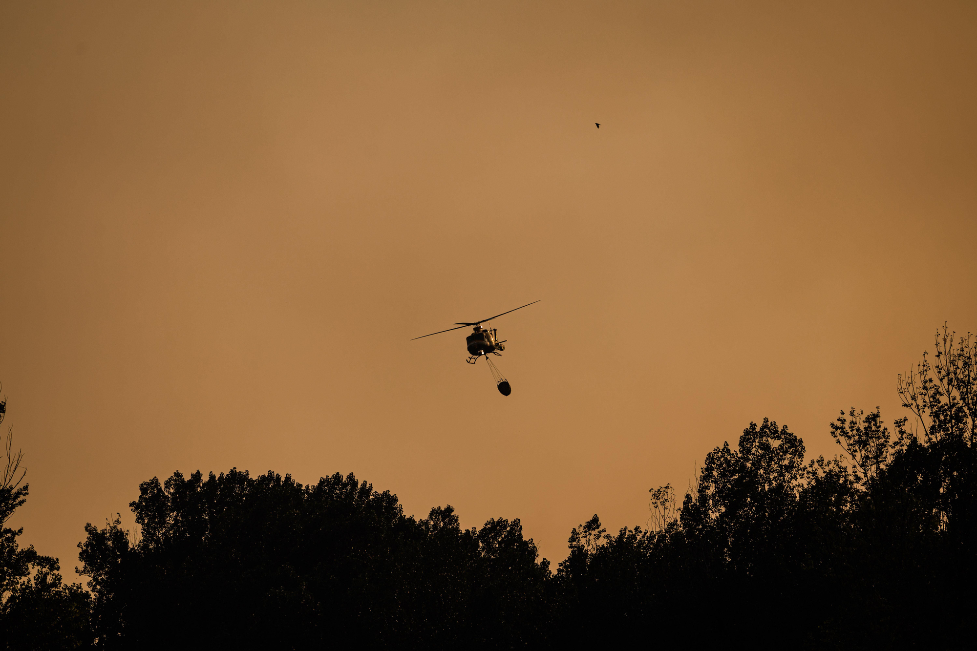 Un helicóptero participa el viernes en las labores de extinción del fuego en Navaluenga, Ávila.