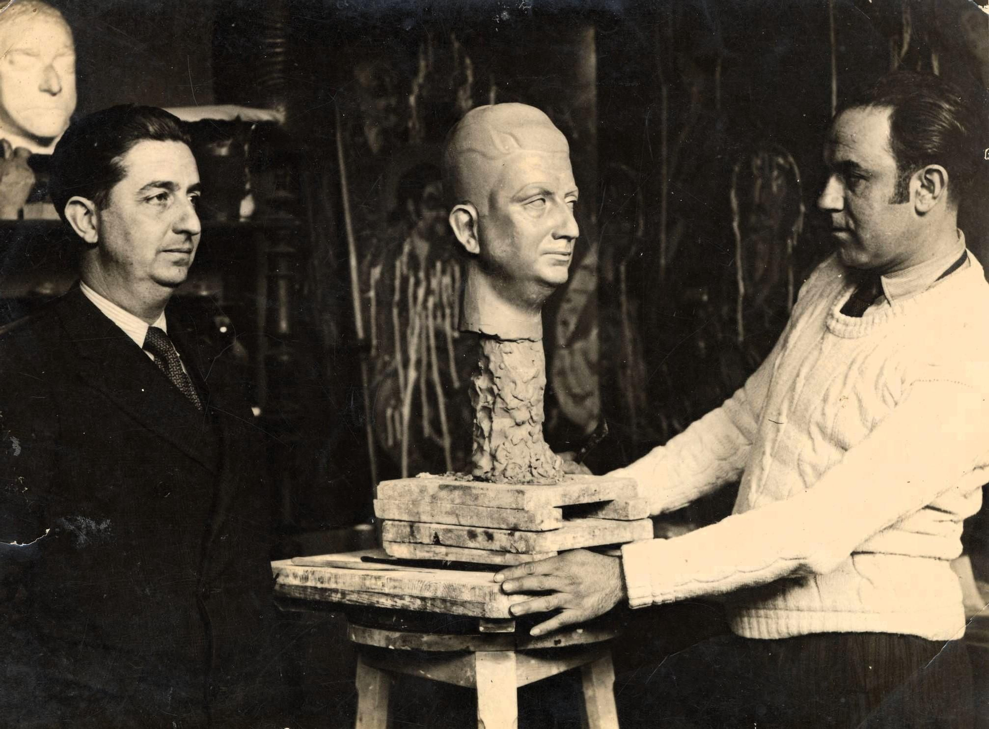 Adolfo Aznar (derecha) modela el busto de Tomás Duch