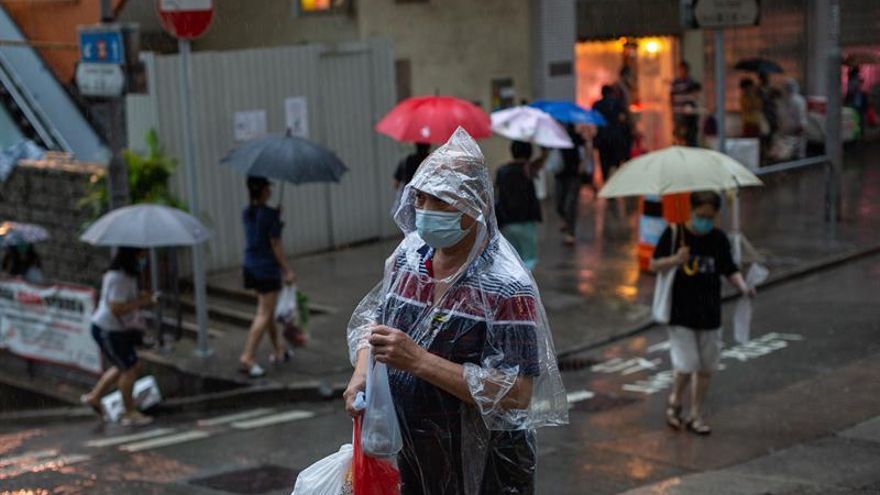 Compradores cruzan una calle durante las fuertes lluvias en Hong Kong, China.