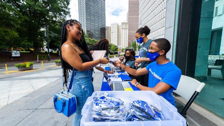 Joshua Grimes, estudiante de segundo año, se encarga de repartir mascarillas con el logo de la mascota de la universidad, una pantera.