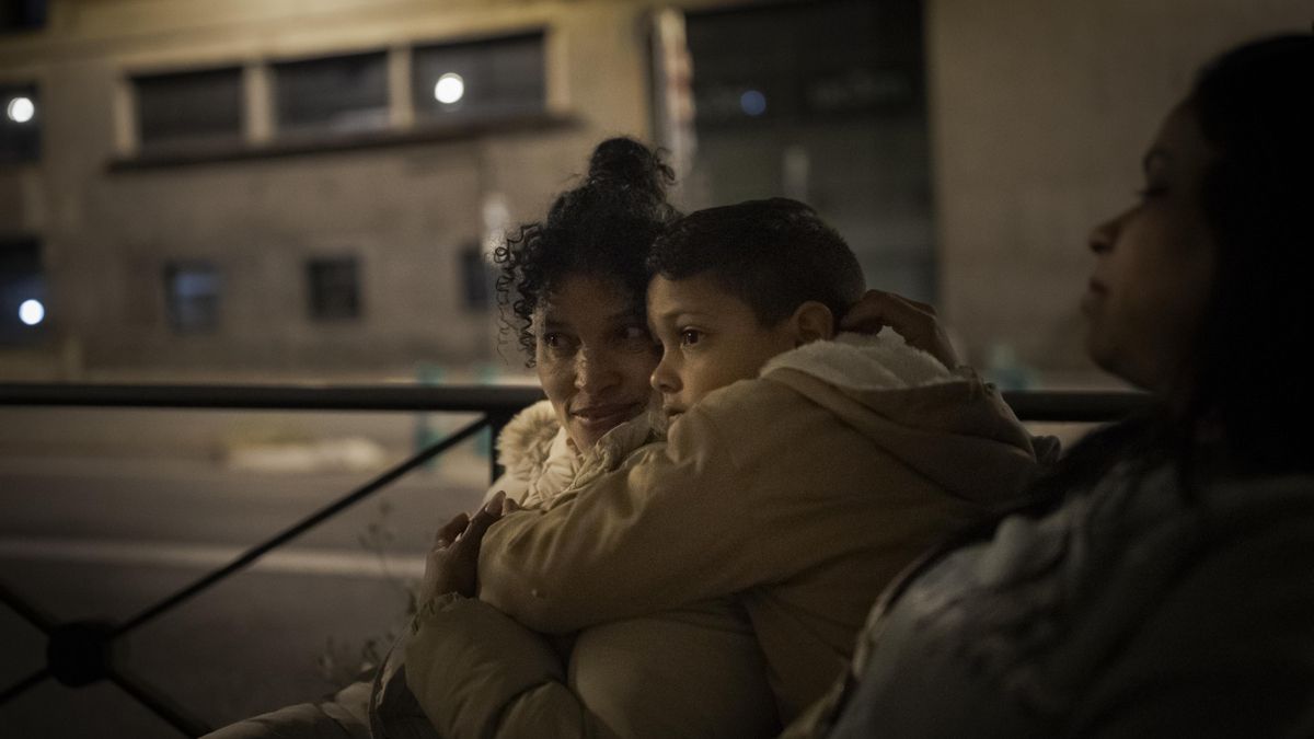 Luz Marina, venezolana, aguarda su turno en la cola de los servicios sociales de Madrid junto a su nieto, que ha ido junto a sus padres un rato para acompañarla y llevarle una chaqueta.