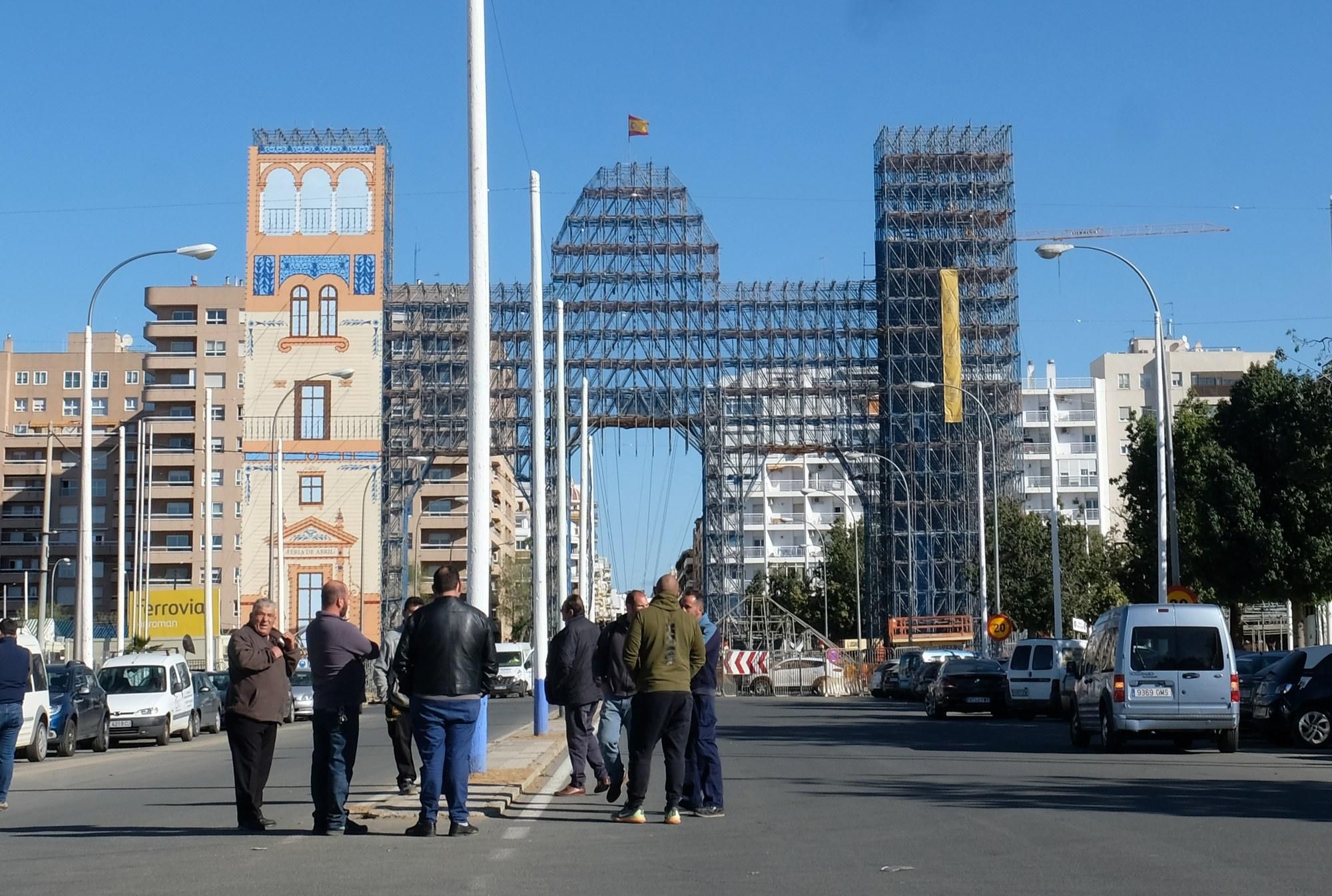 Trabajadores de la Feria delante de la portada que no lucirá este abril en Sevilla./Foto: Luis Serrano