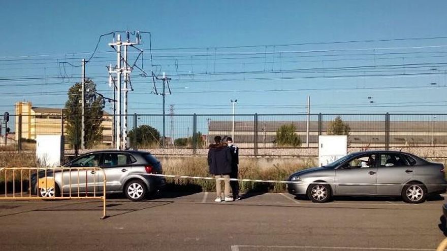 Peatones esperando entre los coches en el entorno del estadio de fútbol de León.