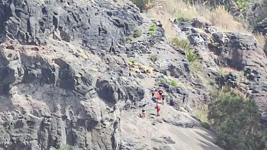 Los efectivos traslandando a la afectada en camilla