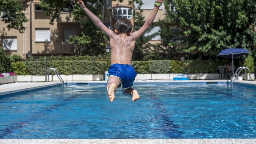 Un niño se lanza a una piscina.