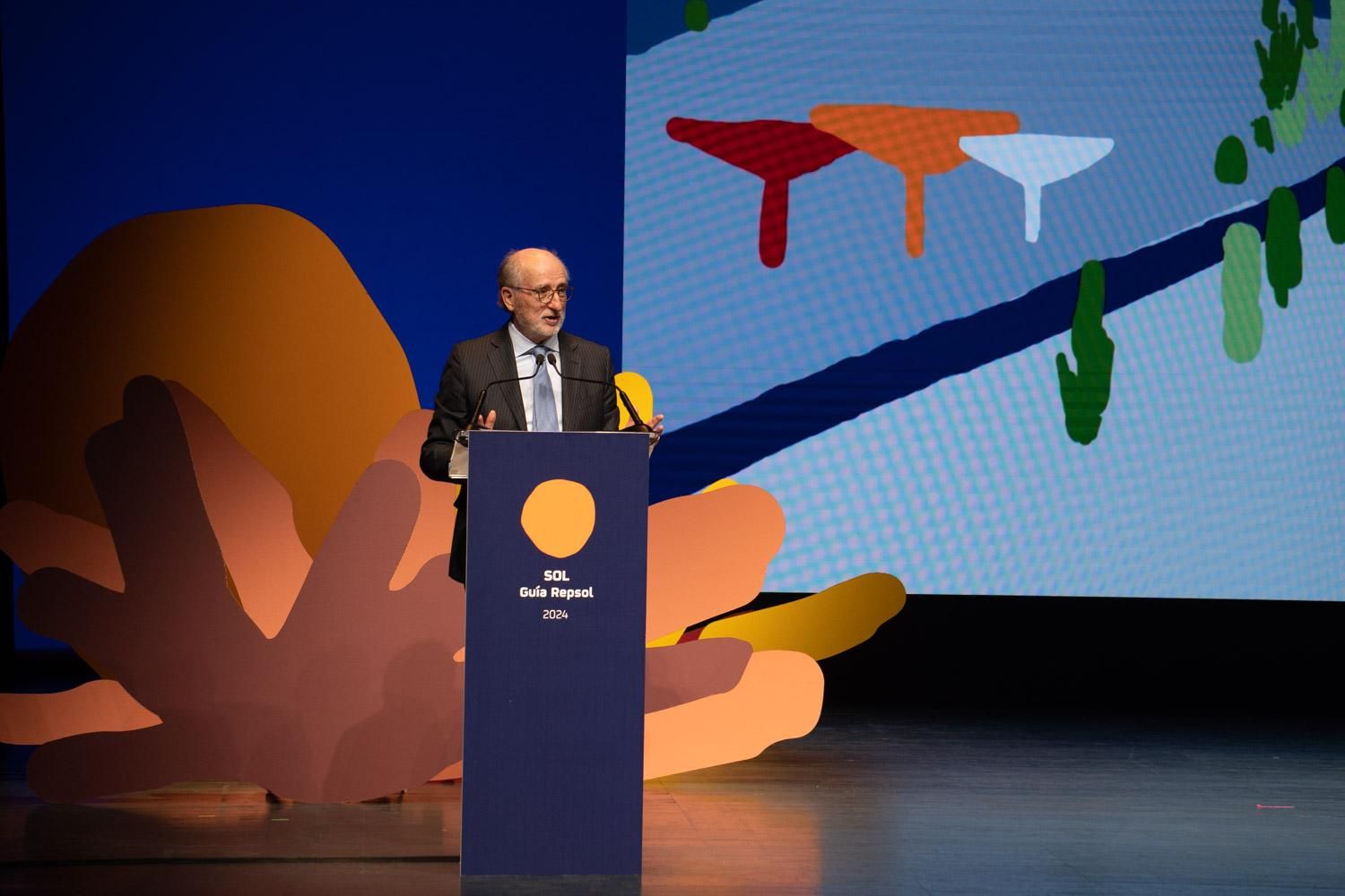 El presidente de Repsol, Antonio Brufau, sobre el atril, aludiendo a la extensa trayectoria, 45 años, de la Guía