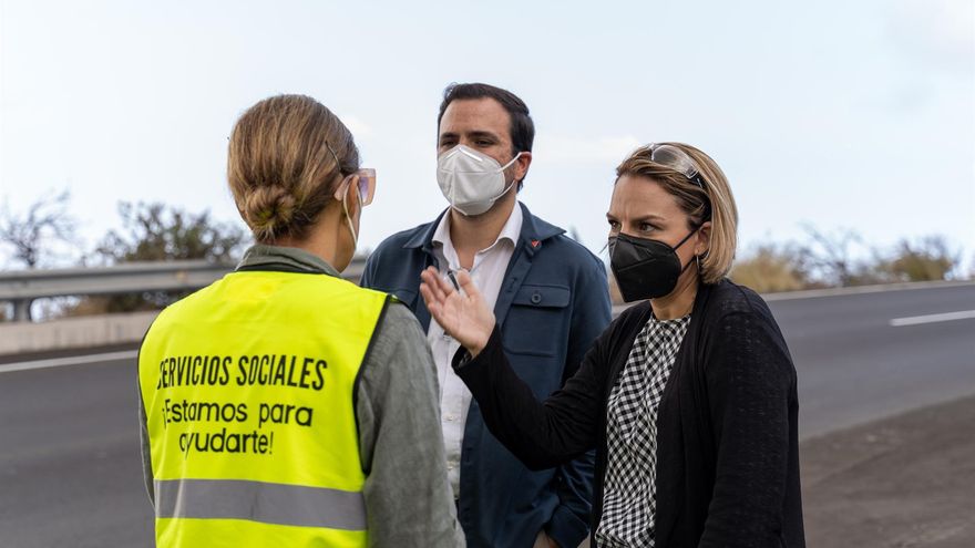 El ministro de Consumo, Alberto Garzón, y la consejera de Derechos Sociales del Gobierno de Canarias, Noemí Santana, conversan con una trabajadora de servicios sociales durante una visita al acuartelamiento de El Fuerte