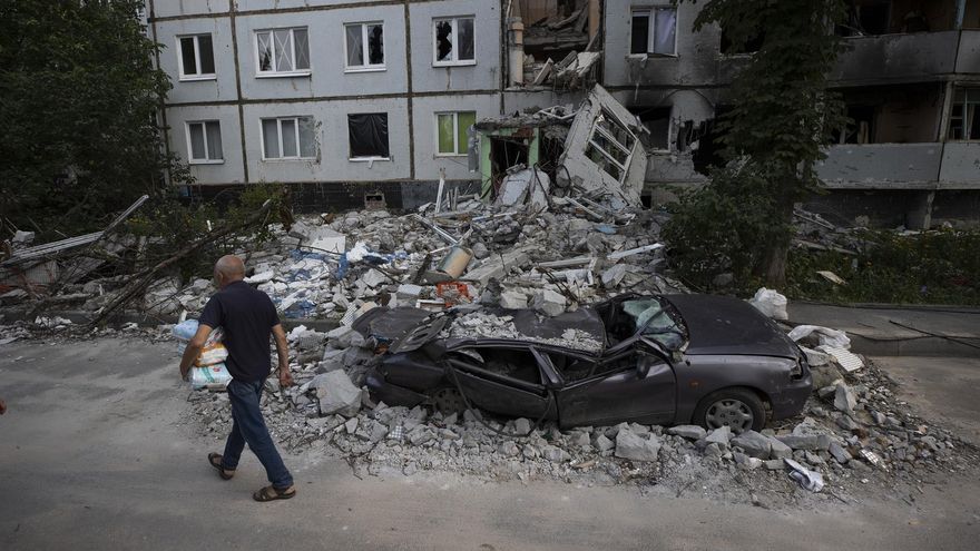Imagen de archivo de un hombre que camina frente a destrozos causados por proyectiles rusos en el barrio Saltivka, en Járkov (Ucrania).