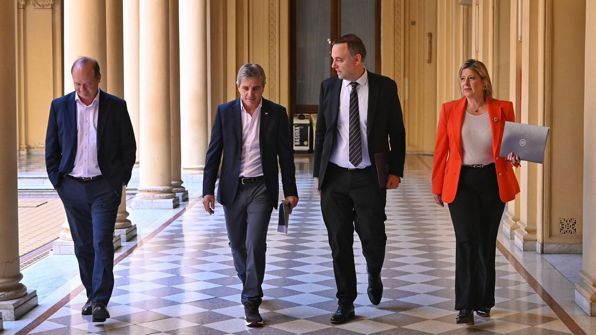 Manuel Adorni caminando junto a Luis Caputo y Alejandra Monteoliva antes de subir a la sala de conferencias.