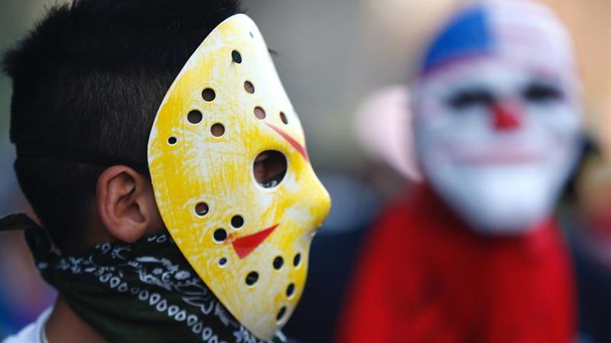 Un par de jóvenes enmascarados fue registrado este jueves al manifestarse, durante la decimotercera jornada de protestas en contra del Gobierno y en demanda de mejoras sociales, en la céntrica Plaza Italia de Santiago de Chile.