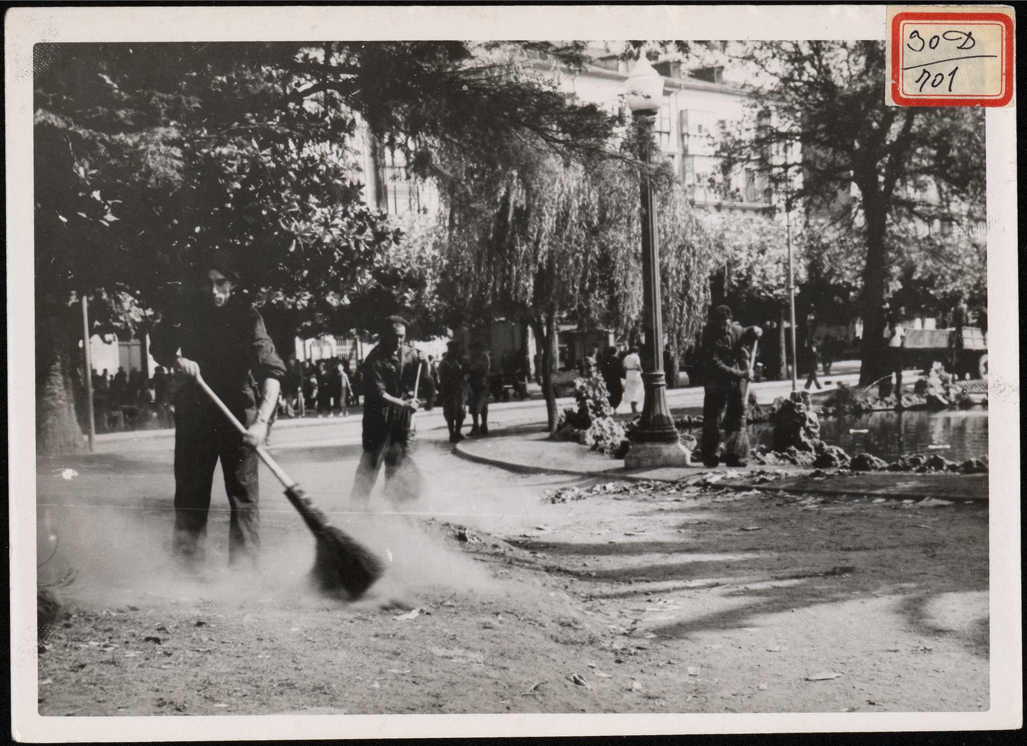 "Barrenderos dedicados a la limpieza de aceras y jardines que al día siguiente ya estaban despejados de evacuados". 30 de agosto de 1937
