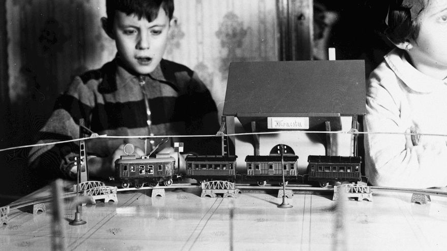 Un niño juega con un tren eléctrico