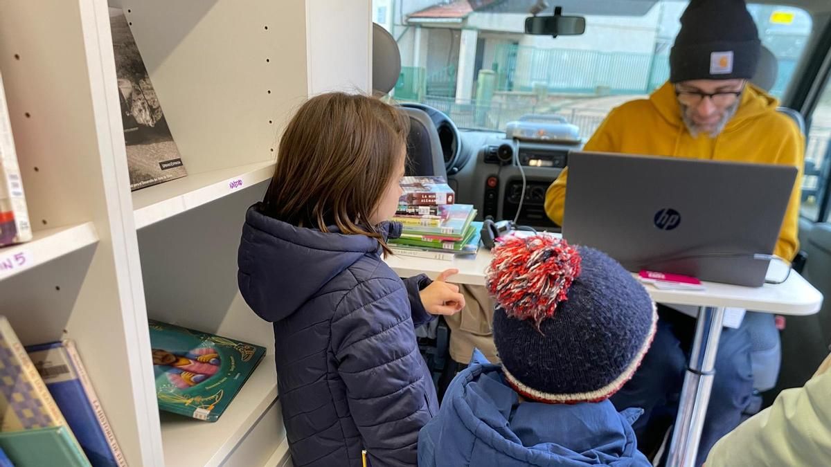 Dos niños eligen sus libros en la Biblioteca Nómada de La Rioja