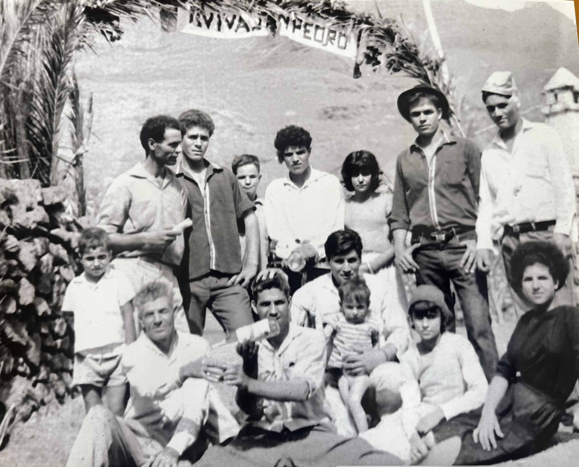 Gabriel Ramírez sostiene a un niño en brazos junto a sus vecinos de El Hoyo en las fiestas de San Pedro. Años 60.