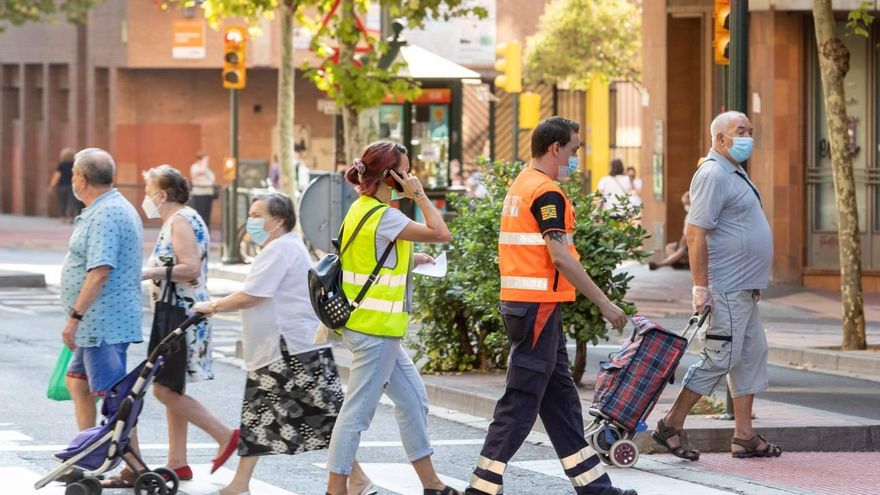 Agosto de 2020. Un trabajador social, acompañado por personal de protección civil, realizaba visitas domiciliarias en el barrio zaragozano de Las Delicias a las personas que habían dado positivo en covid para valorar si podían cumplir el aislamiento de forma correcta. EFE/ Javier Belver