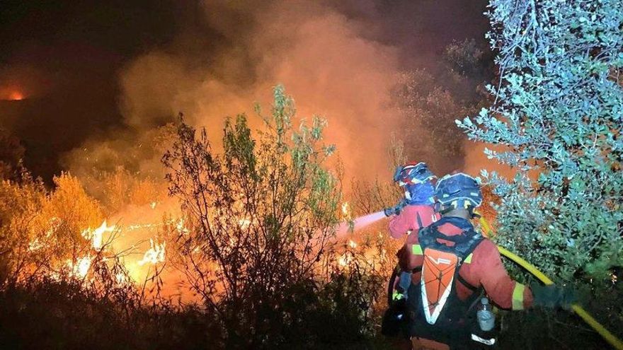 Dos bomberos tratan de controlar el incendio de Tres Cantos el pasado 12 de agosto.