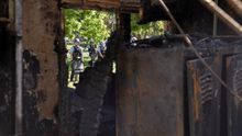 US Park Police can be seen through a hole in a burned out maintenance building that was set ablaze by protestors the night before across the street from the White House during a demonstration over the death of George Floyd, who died in police custody, in Washington, DC, USA.