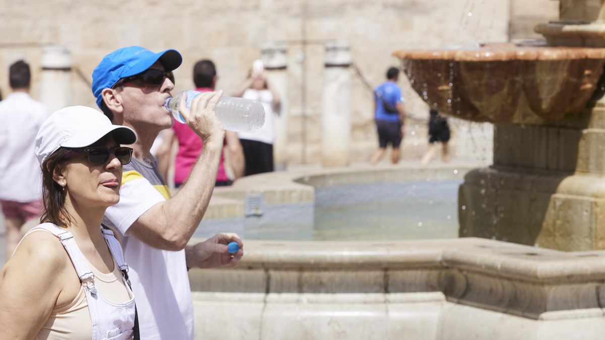 Un hombre se refresca para sobrellevar mejor el calor en Sevilla.