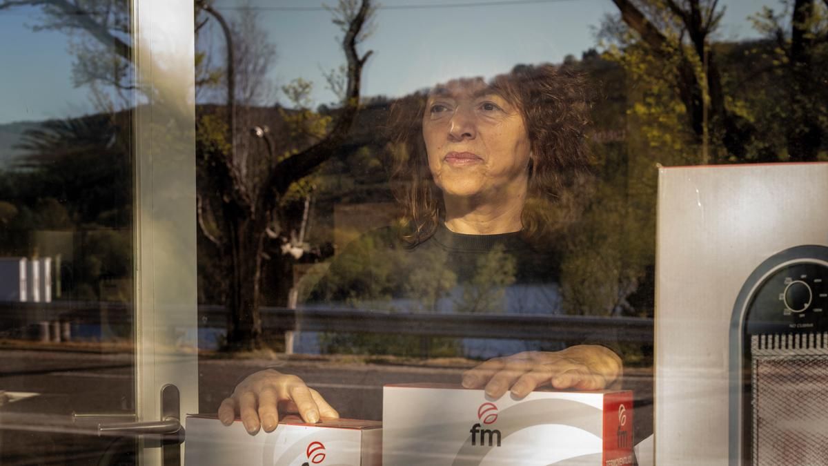 Mercedes Álvarez tiene su tienda de electrodomésticos frente al embalse contaminado en su pueblo, Las Conchas.