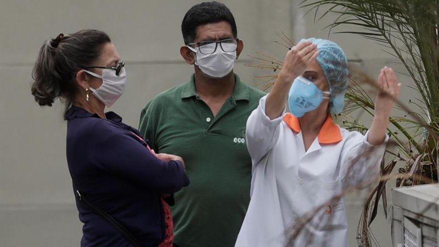 Zilmar Bezerra de Azevedo (i), de 58 años, y su esposo Francisco de Azevedo (c) conversan con una doctora después de que una prueba de coronavirus aplicada a Francisco haya resultado positivo, este viernes en Niterói, ciudad vecina a Río de Janeiro (Brasil).