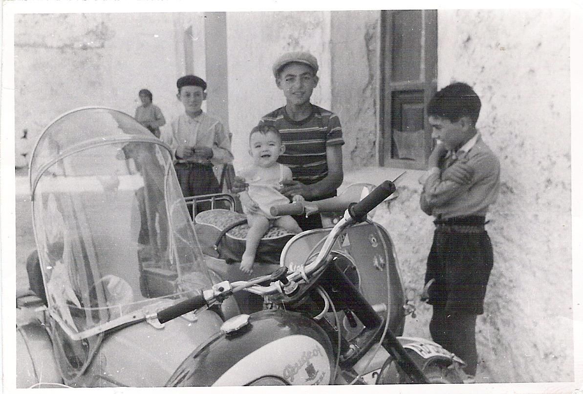 Niños admirando la primera moto con sidecar. Molinicos (Albacete). 1963. Fondo Los Legados de la Tierra. Archivo de la Imagen de Castilla-La Mancha.