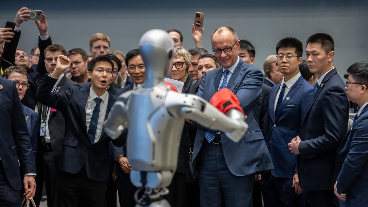 El canciller alemán, Friedrich Merz, durante su visita a la empresa Unitree Robotics en la provincia de Zhejiang, junto a su fundador y director general, Wang Xingxing