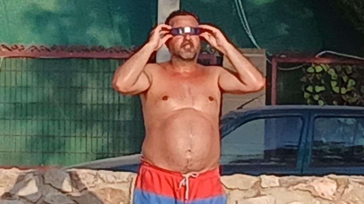 Un hombre probando sus gafas para ver el eclipse total de Sol en las Lagunas de Villafranca de los Caballeros (Toledo)