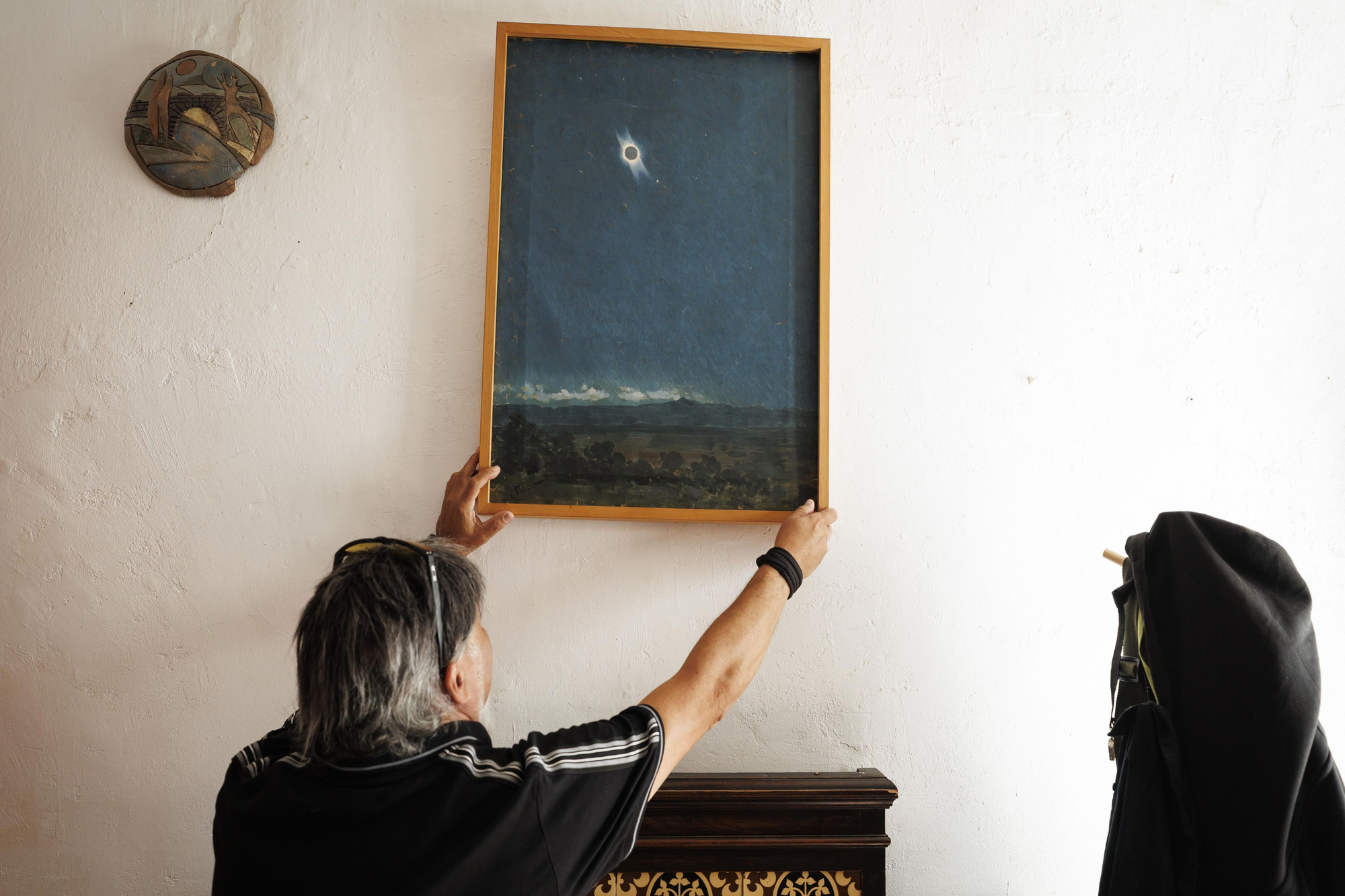 Alfonso Arias descuelga el cuadro de la pared de su casa de Salobreña.