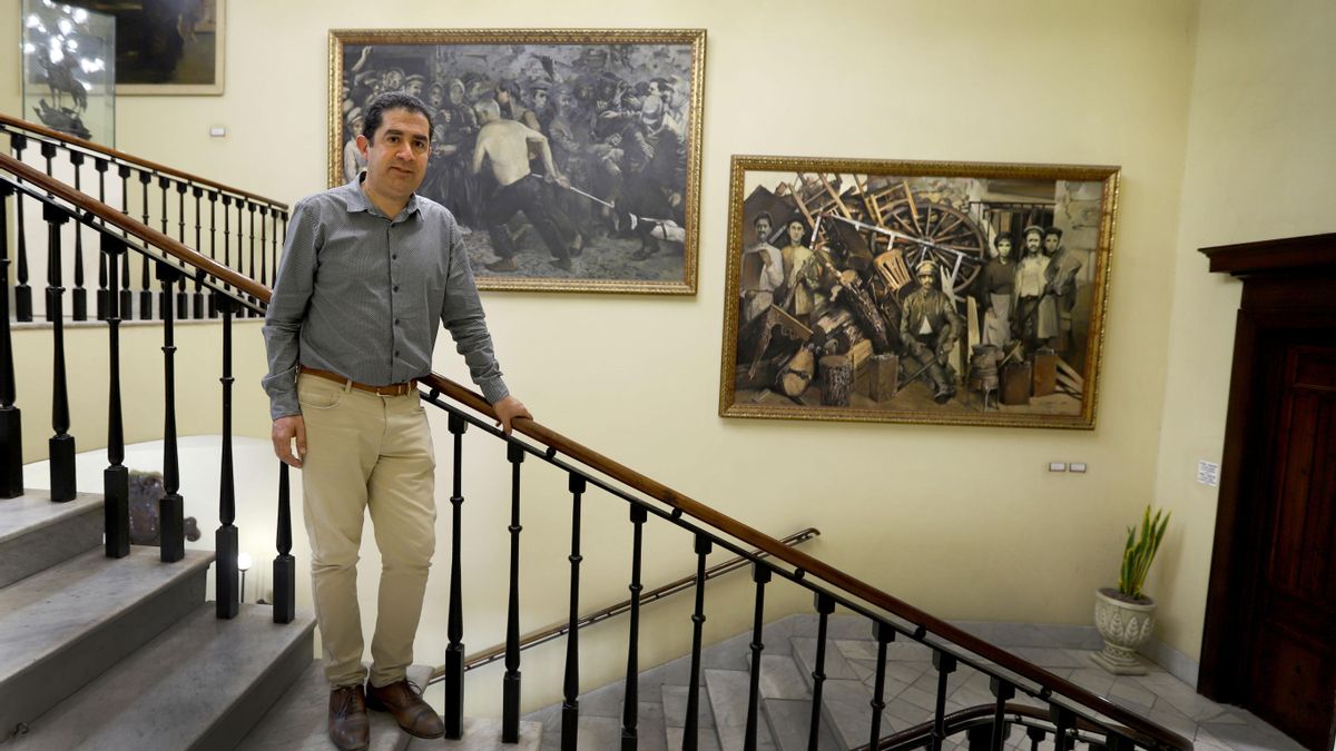 Toni Francés, davant d'uns quadres de la revolució industrial a l'Ajuntament d'Alcoi.